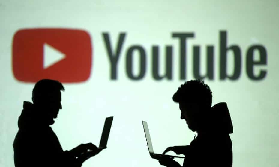 Mobile device users are seen next to a screen projection of Youtube
