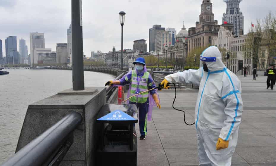 Sanitation workers wearing PPE conduct disinfection work in Shanghai.