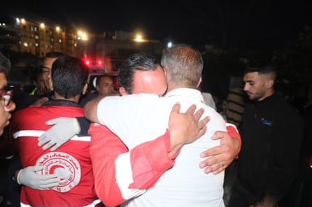 People in Red Crescent uniforms embracing.