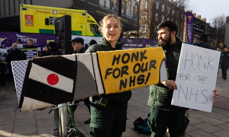 Paramedics hold placards in support of the NHS.
