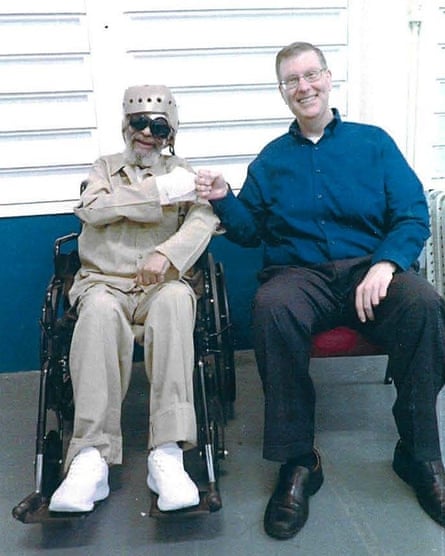 man in wheelchair fist bumps man sitting in chair