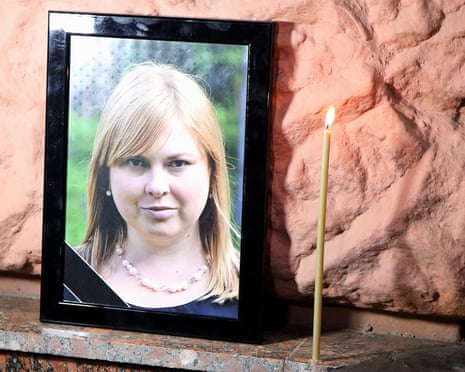 Picture of Kateryna Handzyuk with a candle next to it at rally.
