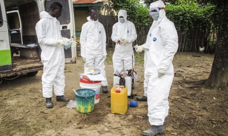 Health workers prepare to enter the house of a person suspected to have died of Ebola on the outskirts of Freetown, Sierra Leone.