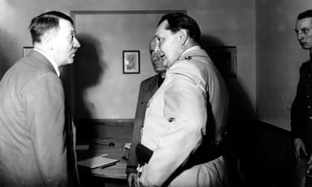 Hermann Göring speaks with Adolf Hitler as Benito Mussolini looks on
