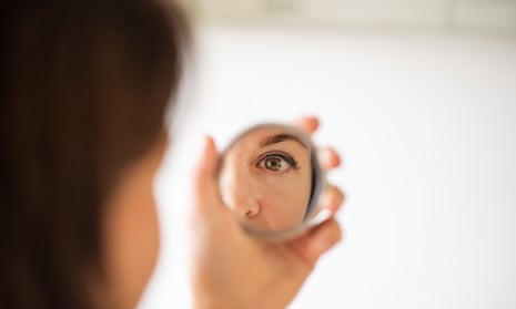 A woman looking at herself in the mirror.