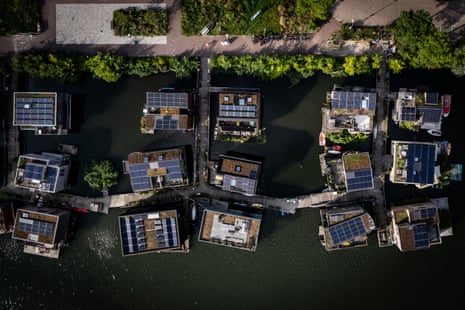 Aerial view of individual houses surrounded by water. They have solar panels on the roofs