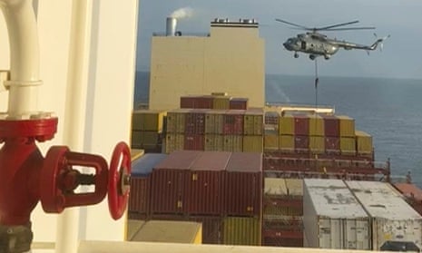 An image from the Associated Press shows a helicopter targeting a vessel near the Strait of Hormuz.