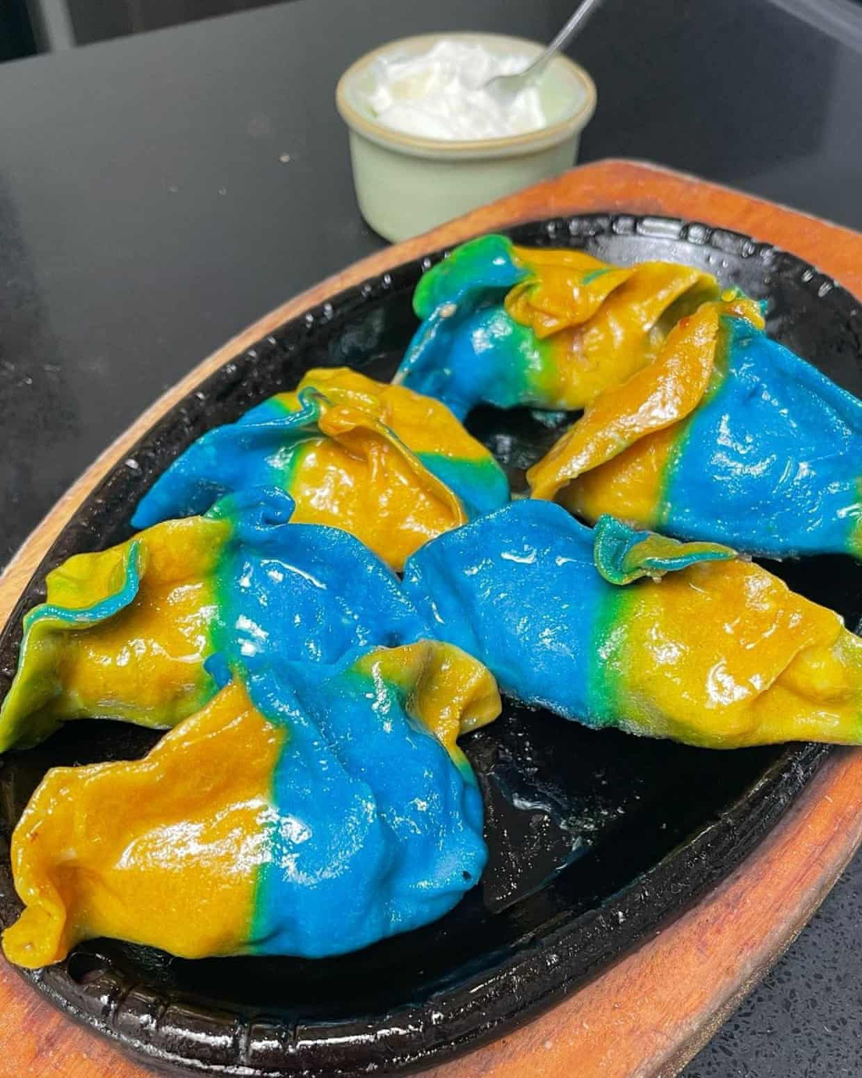 A plate of blue and yellow dumplings.