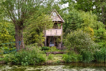 Pond and wooden two storey building among the bushes and trees