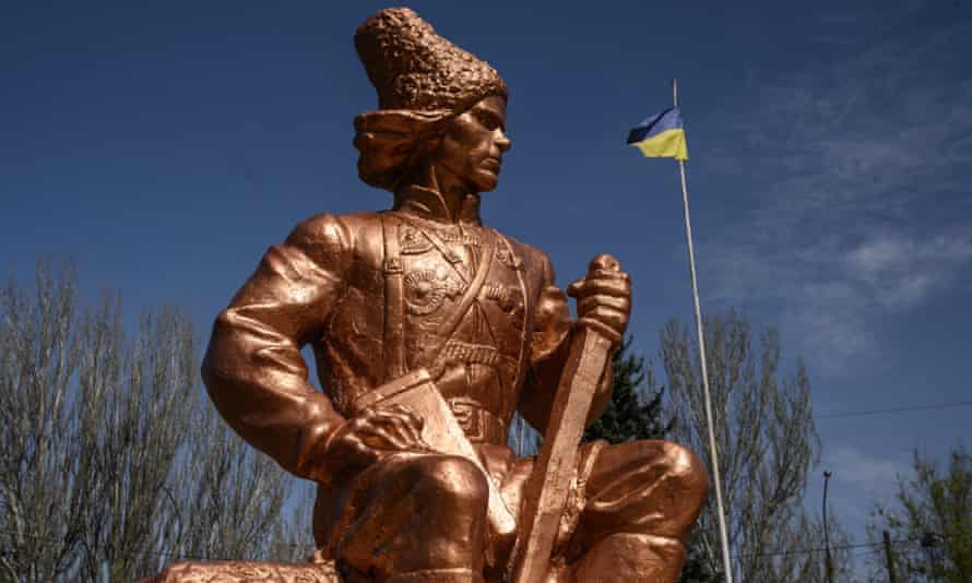 Die ukrainische Flagge weht hinter einer Statue von Nestor Makhno in Saporischschja im Südosten der Ukraine.