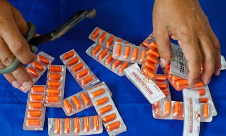 A worker cuts blister packs of ivermectin capsules