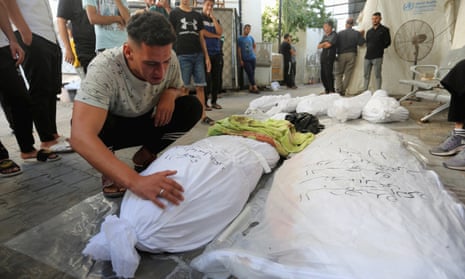 A Palestinian man mourns over the bodies of loved ones killed in Israeli strikes, in Rafah in the southern Gaza Strip, 30 October 2023.