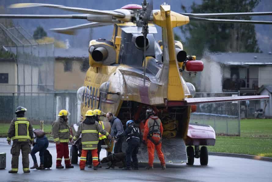 Search and rescue personnel help flood evacuees disembark from a helicopter in Agassiz, British Columbia, on Monday.
