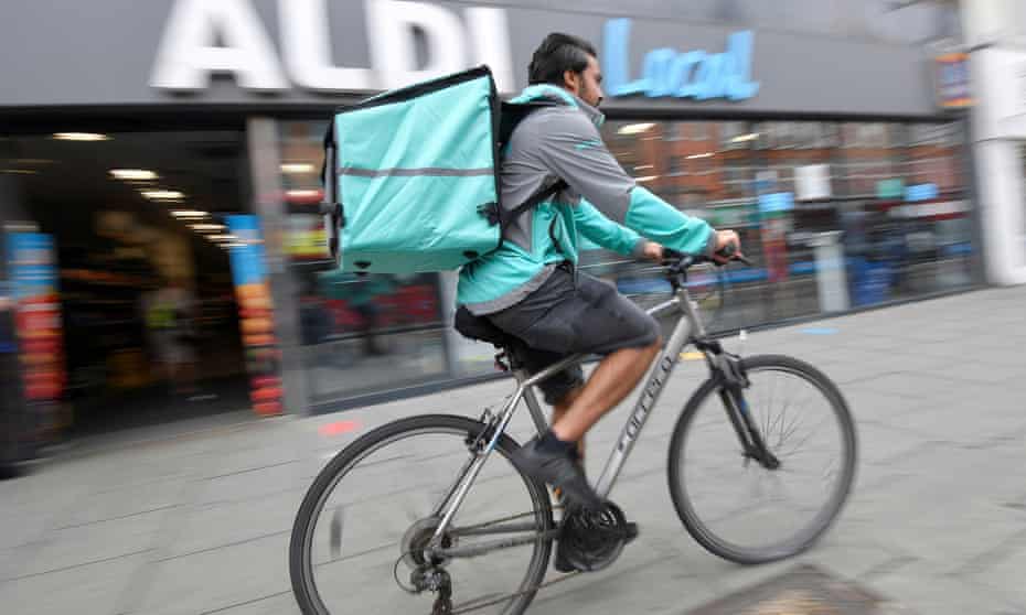 A Deliveroo delivery rider with a bag of Aldi groceries, London, Britain