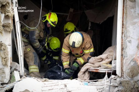 Rescuers prepare to carry a person in a body bag out of a damaged building in Odesa.