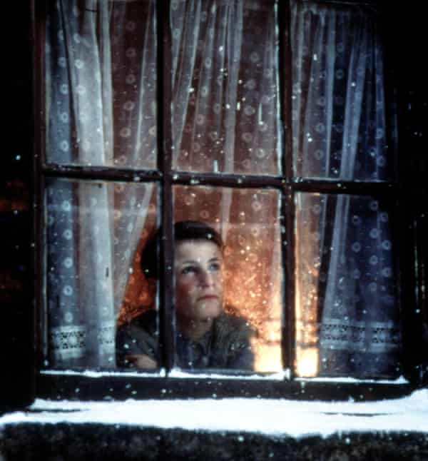 A boy looks out the window at snow in The Long Day Closes