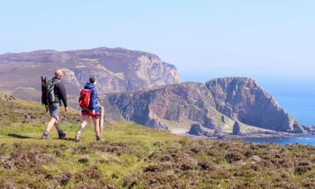 Les randonneurs admirent une belle vue côtière sur un chemin au sommet d'une falaise.