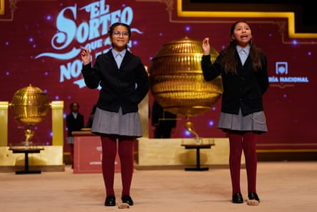 Two children in their school uniform singing on stage