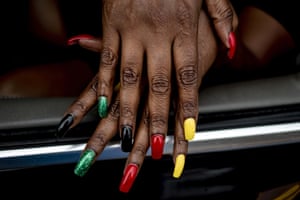 Flint resident Tracy Palmer shows off her Juneteenth-inspired nails during one of two parades celebrating the holiday along Saginaw Street in downtown Flint, Michigan