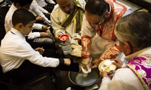 A priest washes a boy’s feet during Maundy Thursday mass at Mar Hanna church