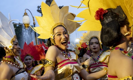 Bailarines balineses actúan mientras participan en un desfile cultural, durante la celebración de la víspera de año nuevo en una carretera principal en Denpasar, Bali, Indonesia.