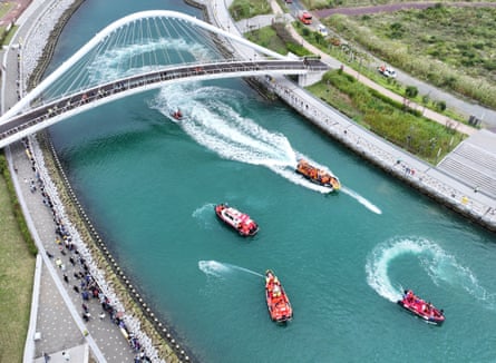 This aerial photo taken on 29 September shows the South Korean Coast Guard boats spraying water in an attempt to guide the shark back to the sea.