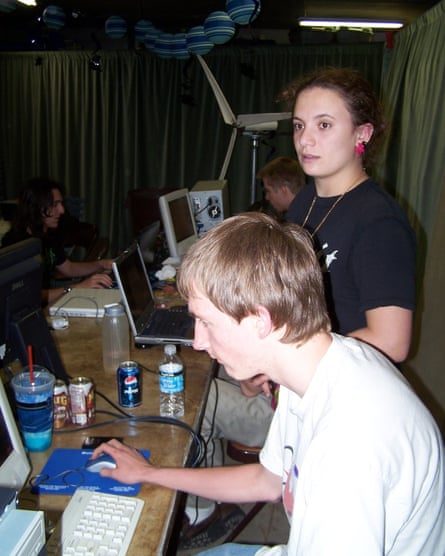 Young people sitting at a table, with drinks and laptops on it