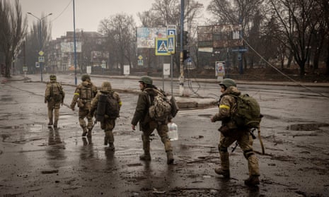 Ukrainian troops move through the streets of Bakhmut, eastern Ukraine, as fighting against Russian forces rages