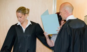 Andrea Göppner hides her face as she arrives with her lawyers at the district court of Coburg, Germany.