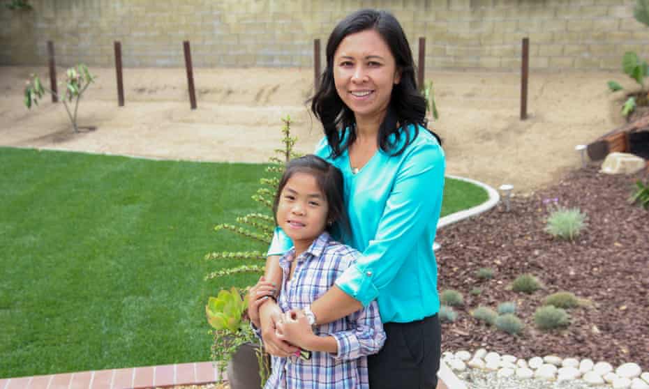 Yumi Wong and daughter Kayley in front of their new lawn, half grass and half drought-tolerant landscaping.