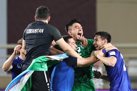 Uzbekistan’s players celebrate in a huddle.