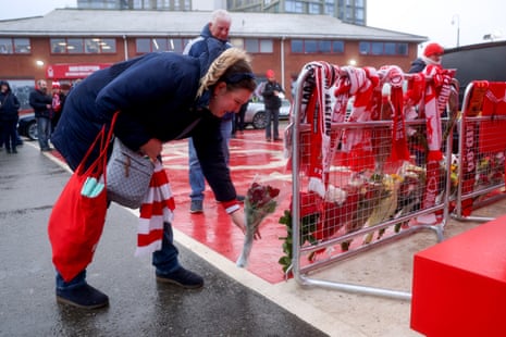 A Nottingham Forest fan lays a bouquet of flowers as a tribute in memory of former Nottingham Forest player John Robertson.