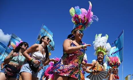 A carnival samba band parades through the festival site.