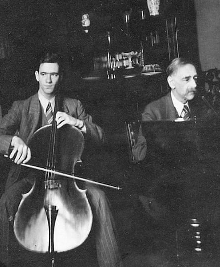 An old black and white image of two men playing music together (father and son)