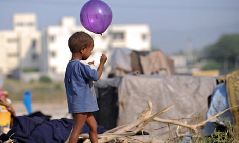 A Pakistani child plays with a balloon in front of his makeshift tent on the outskirts of Islamabad