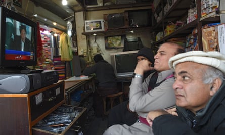 Pakistani shopkeepers watch Imran Khan’s televised speech.