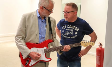 Labour leader Jeremy Corbyn tries out a guitar with John Newhouse of a local charity Trust Music during a visit to Bolton.