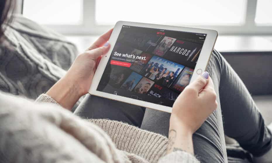 A woman watches Netflix on an iPad