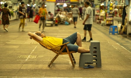 A man rests at a fresh food market in Shanghai, China