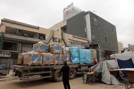 A man stands next to a truck carrying Unicef aid supplies outside a shopping mall