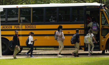 Elementary School students board a school bus.