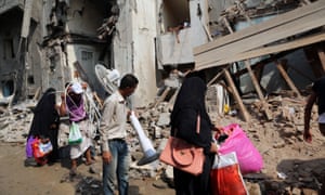 Yemenis carry belongings they recovered from the rubble of buildings destroyed during Saudi-led air strikes in Hodeida