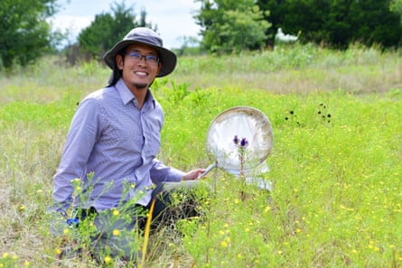 A man in a field holding an insect net