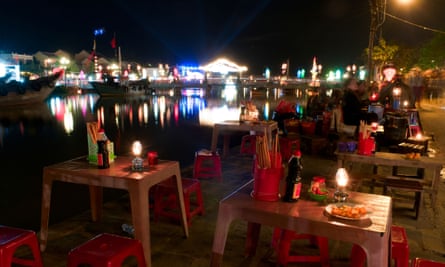 Street food stalls by the Thu Bon river lit with lanterns at night, Hoi An, Vietnam.