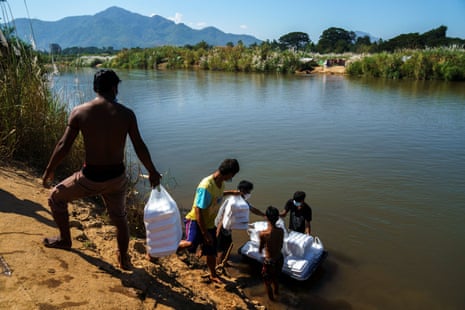 Myanmar refugees receive aid on the Thai-Myanmar border, in Mae Sot in January 2022.