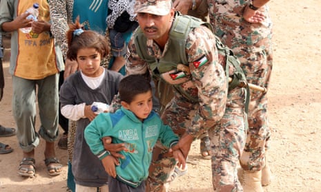 A Jordanian soldier helping Syrian children on their arrival at the border in September 2015.