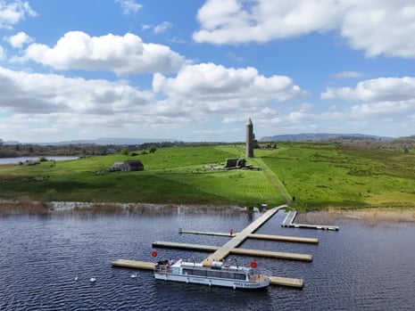 Boat moored on a lake with a jetty with a tower behind