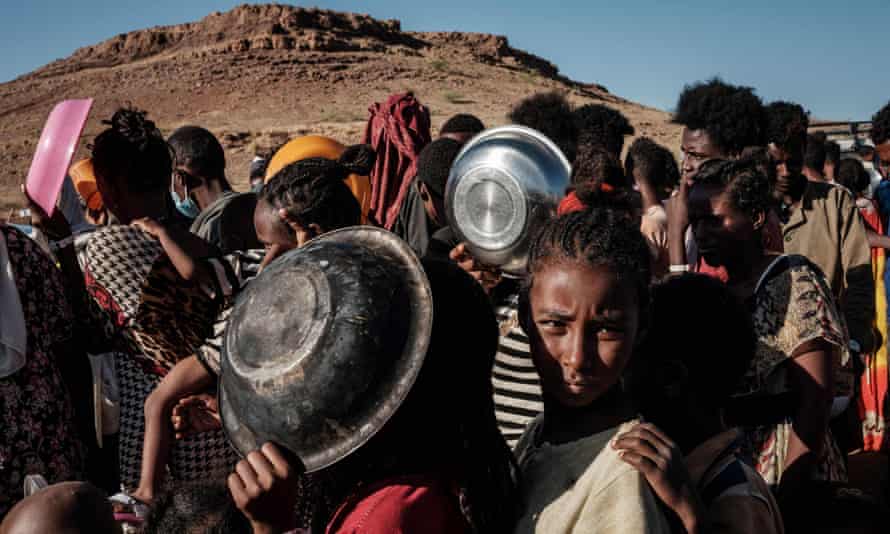 Ethiopian refugee children who fled the Tigray conflict wait in a line for a food distribution by Muslim Aid at the Um Raquba refugee camp in Sudan.