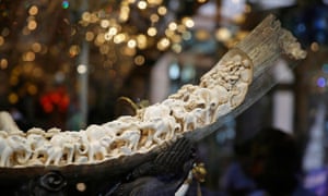 Carvings of elephants and other animals are displayed inside a mammoth ivory tusk, in a shop window in Chinatown, San Francisco.