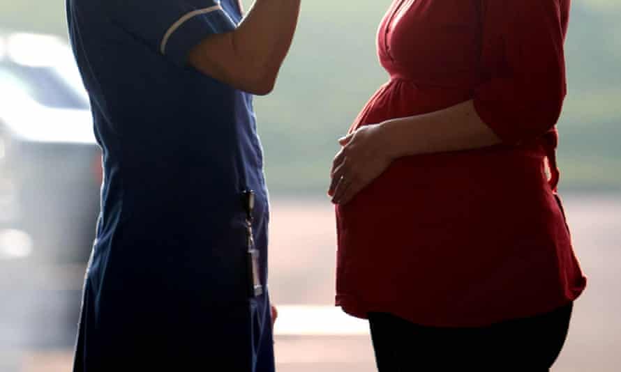 A midwife talking to a pregnant woman.